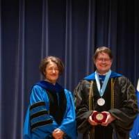 Provost smiles for picture with faculty
